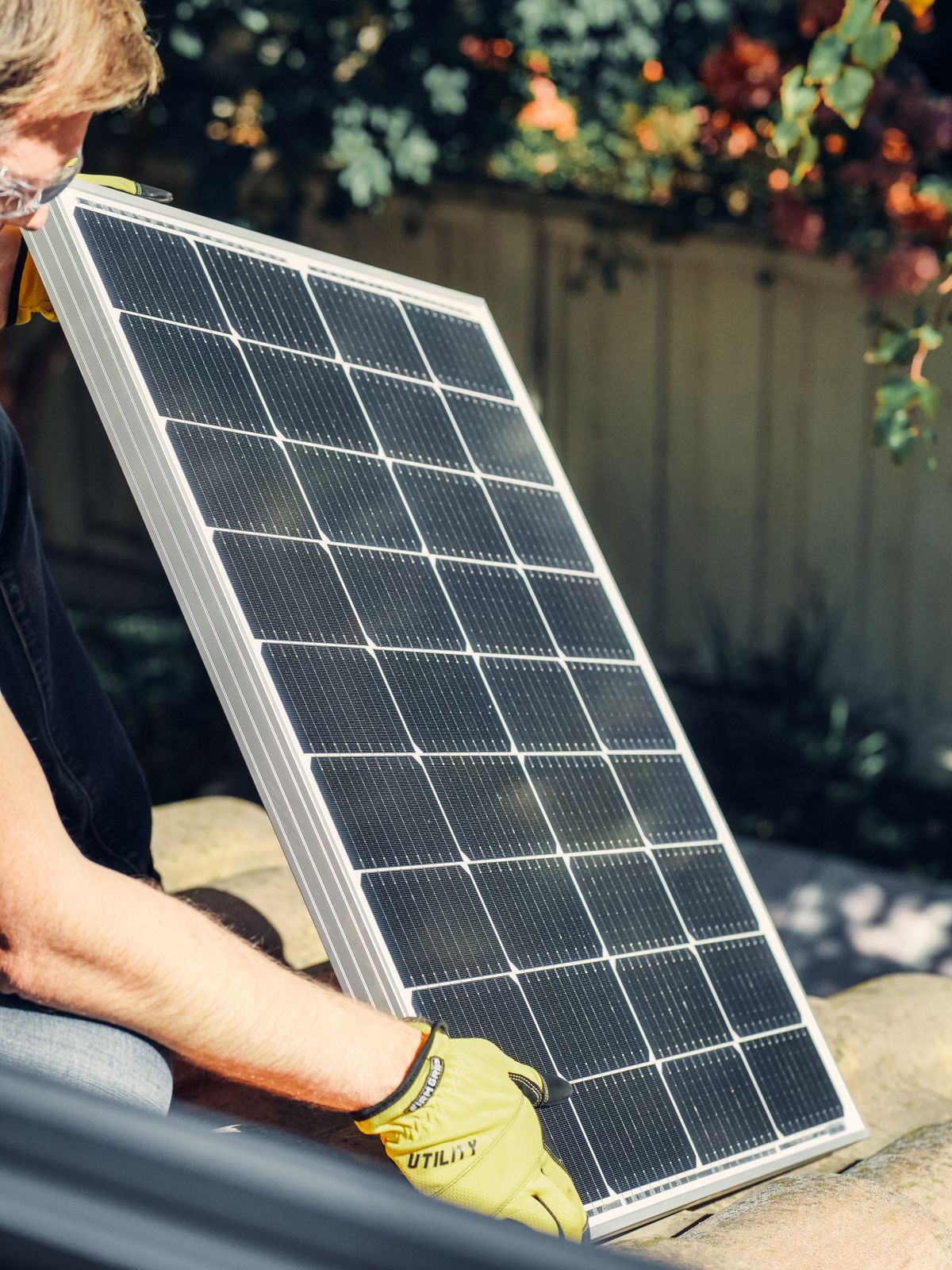 Hands lifting a solar panel into position