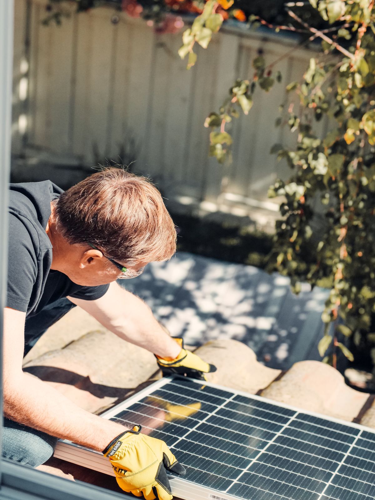Installer fitting solar panels onto a tiled roof